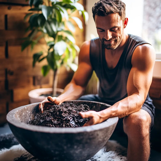 man sitting down using body scrub, hands in product